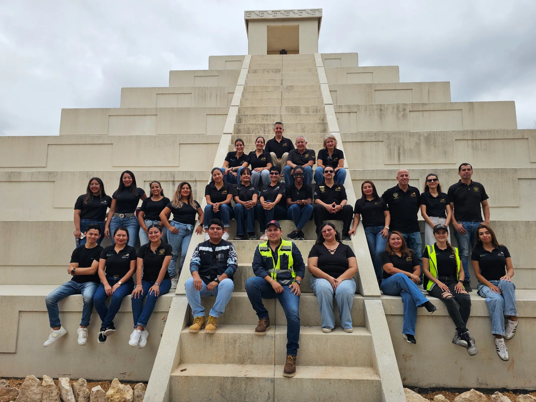 Fotografía grupal del equipo Grupo DAXI reunido frente a una estructura escalonada de piedra clara.
