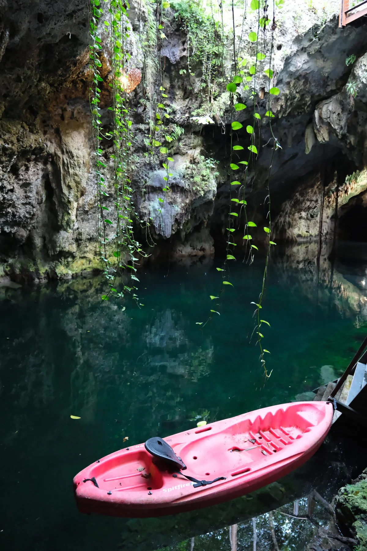 Cenote natural de Mukta con un kayak rojo sobre el agua